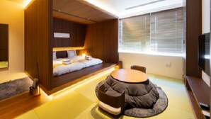 A modern room with a built-in bed, a round coffee table, and a TV. - TORIFITO HOTEL&POD KANAZAWA Hyakumangoku-Dori (Kanazawa)
