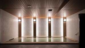 A modern, minimalist indoor pool area with a reflective floor, wooden ceiling panels, and recessed lighting. - TORIFITO HOTEL&POD KANAZAWA Hyakumangoku-Dori (Kanazawa)