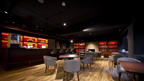 A modern restaurant with a bar area, seating, and a bookshelf. - TORIFITO HOTEL&POD KANAZAWA Hyakumangoku-Dori (Kanazawa)