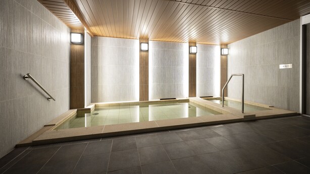 A modern indoor swimming pool with clear water, wooden ceiling panels, and tiled walls. - TORIFITO HOTEL&POD KANAZAWA Hyakumangoku-Dori (Kanazawa)