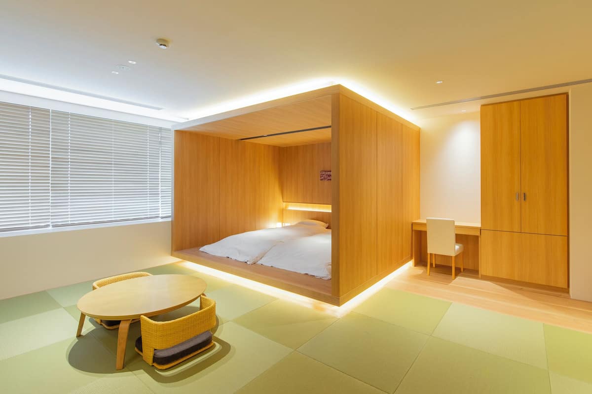 Una habitación moderna con una cama, un escritorio y una silla.