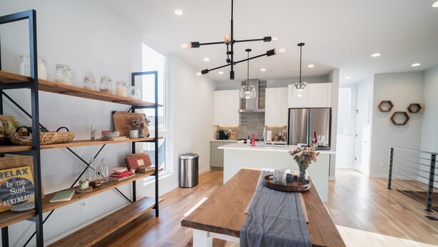 A modern kitchen with wooden shelves, a central island, and a hanging light fixture. - Insta-worthy Views, Wine, Rooftop Firepit on Beach (Seattle)