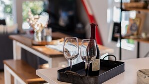 A modern kitchen with a white countertop, two wine glasses, and a wine bottle on a tray. - Insta-worthy Views, Wine, Rooftop Firepit on Beach (Seattle)