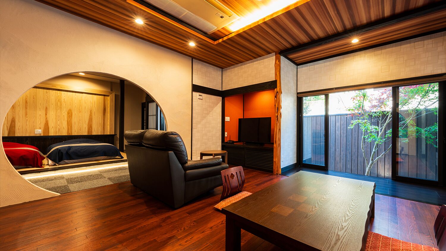 Un interior moderno con un sofá, una mesa y vistas a través de un ventanal.