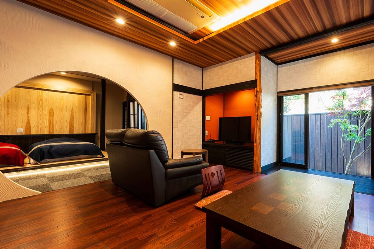 A modern interior with a sofa, a table, and a view through a glass door.