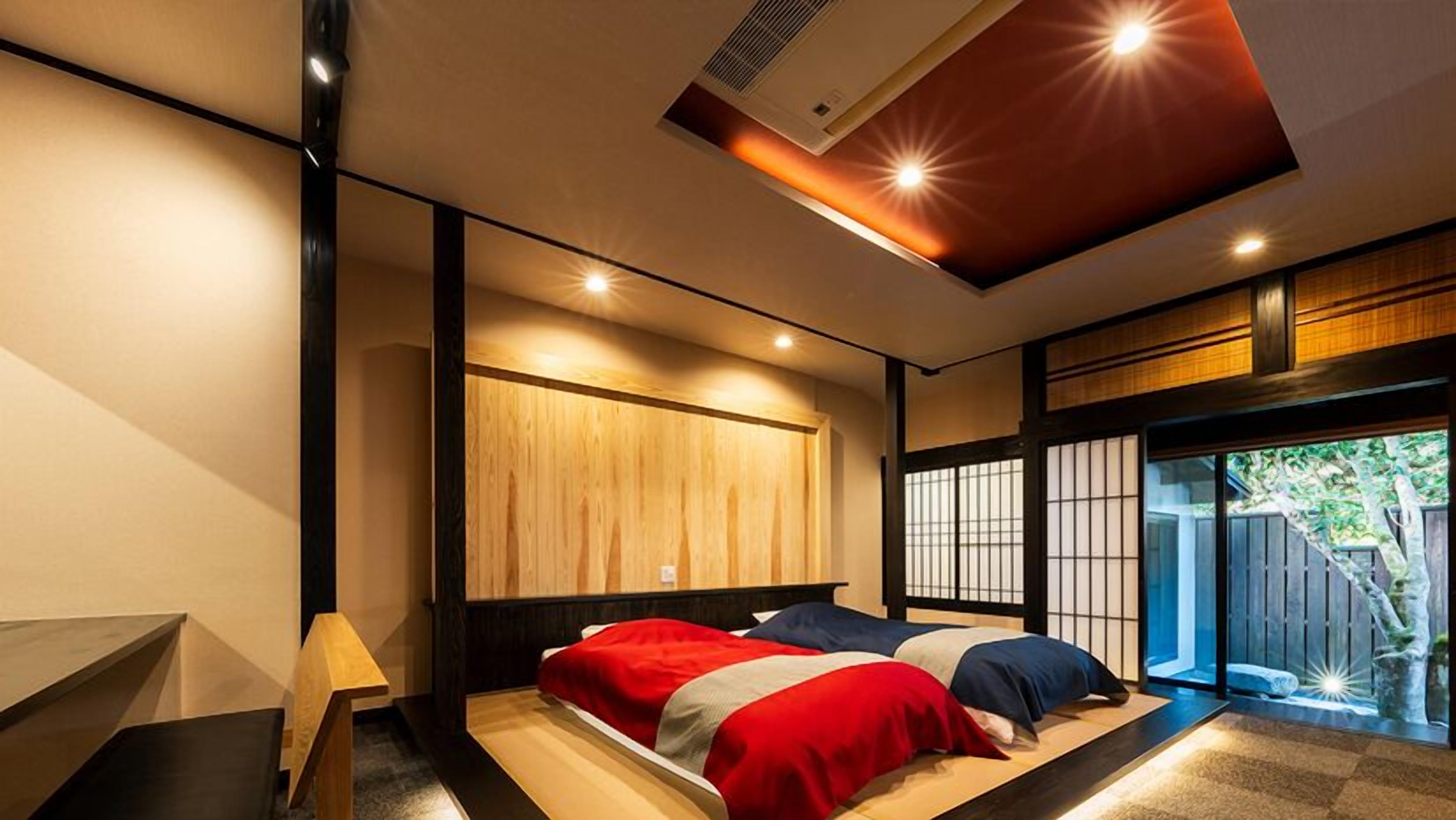 Un dormitorio moderno con una cama grande, panel de pared de madera, puertas correderas y una lámpara de techo.