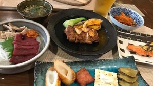 A table with various dishes including meat, vegetables, and a glass of beer. - Oyado Furaibo (Kitashiobara)