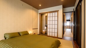 A hotel room with a large bed, a traditional sliding door, and a view of the hallway. - Iroha Nozawa (Nozawaonsen)