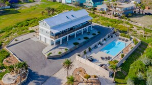 An aerial view of a coastal property with a large building, a swimming pool, and landscaped areas. - Bikini Bottom 2Bed 2Bath Ocean View Huge Outdoor Pool - DOWNSTAIRS UNIT (Port Aransas)