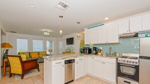 A modern kitchen with white cabinets, a built-in dishwasher, a stove, and a microwave. - Bikini Bottom 2Bed 2Bath Ocean View Huge Outdoor Pool - DOWNSTAIRS UNIT (Port Aransas)