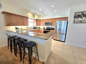 A modern kitchen with granite countertops, stainless steel appliances, and wooden cabinets.