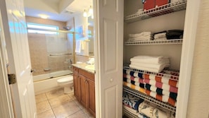 Une salle de bain équipée d’une baignoire, de toilettes et d’un porte-serviettes avec des serviettes pliées.