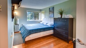 Ein Schlafzimmer mit Bett, Schminktisch und Fenster.