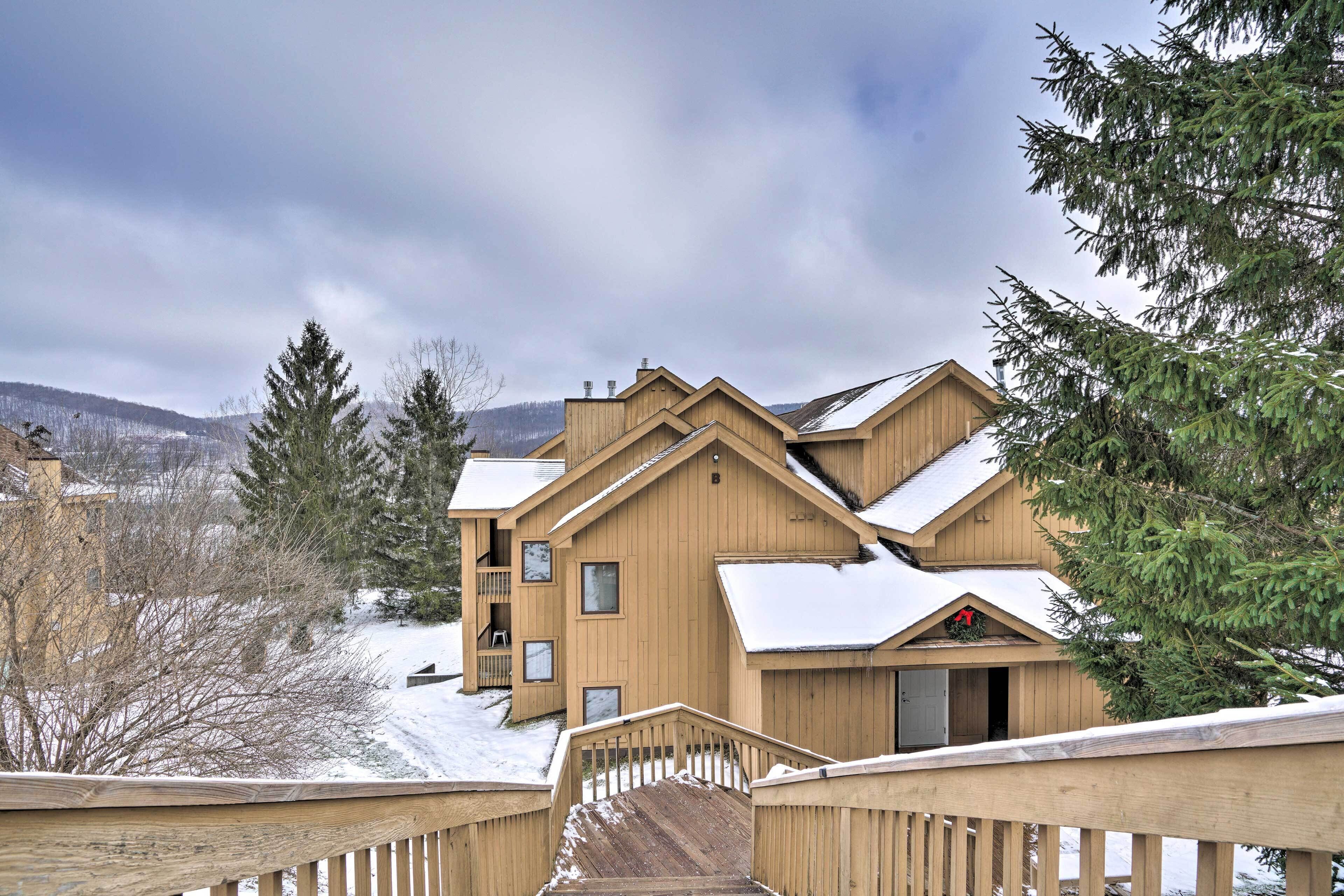 A wooden lodge with multiple balconies and a staircase leading to the entrance.