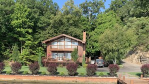 Un chalet au bord du lac, doté d’une terrasse et d’un quai s’avançant dans l’eau.