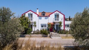 A two-story building with a red and white facade, a balcony on the second floor, and a small window on the first floor. - Villa Marilia - Lux home near Beach (Rhodes)