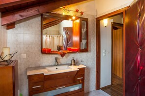 A bathroom with a wooden vanity, a large mirror, and a red curtain door. - Villa Marilia - Lux home near Beach (Rhodes)