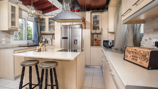 A modern kitchen with a central island, stainless steel appliances, and a hanging light fixture. - Villa Marilia - Lux home near Beach (Rhodes)