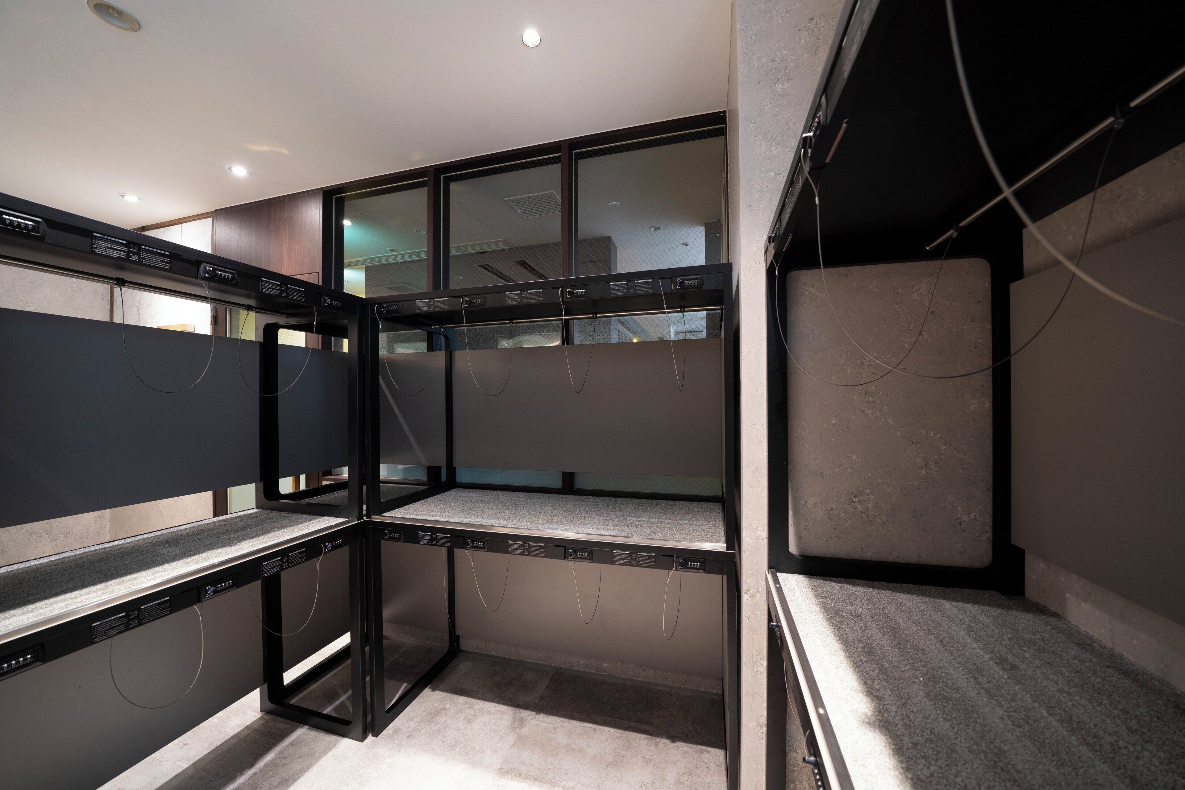 A compact, industrial-style room with built-in shelving units, a window, and visible electrical wiring.