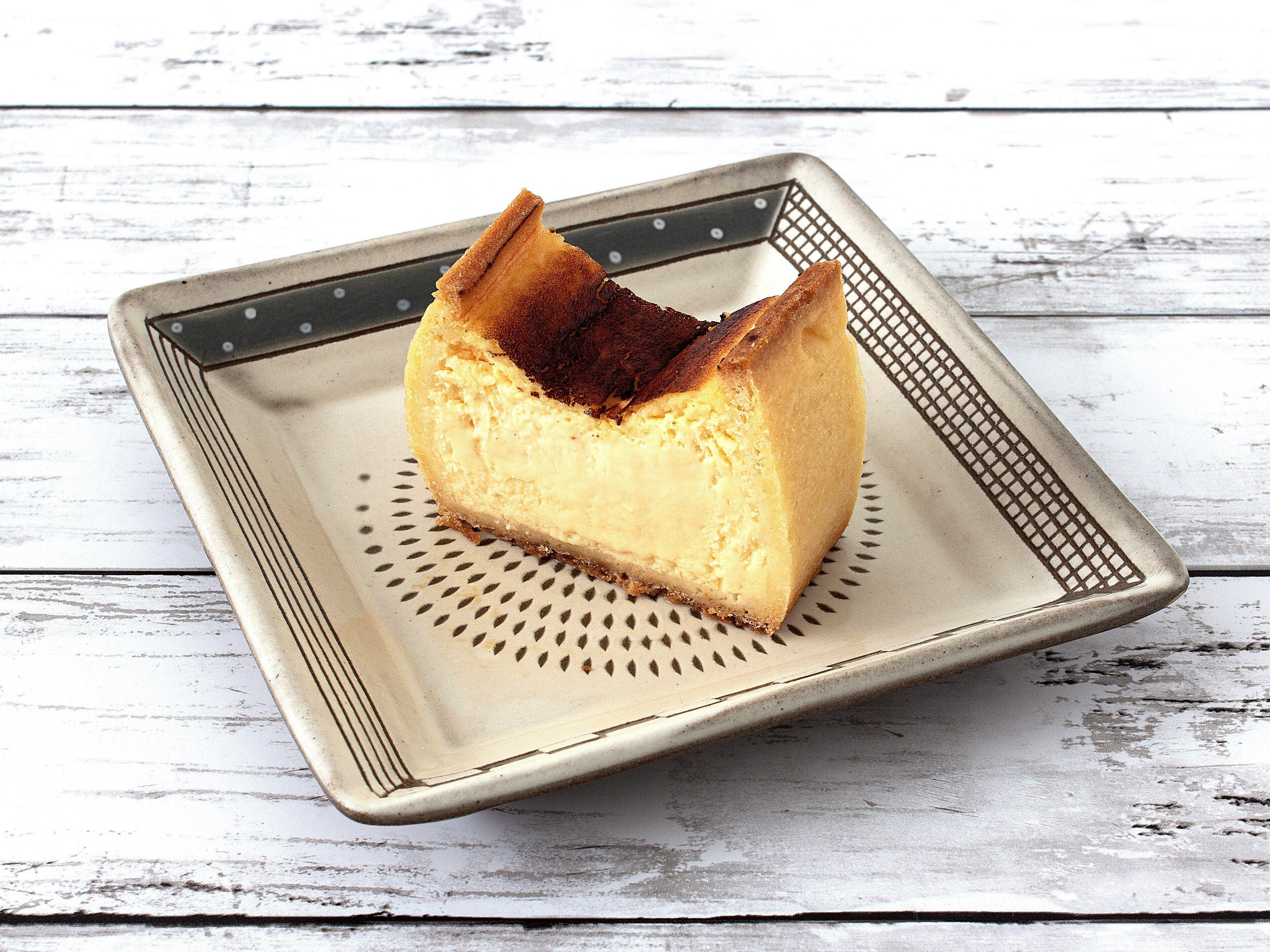 Un pastel de queso en un plato cuadrado con un borde decorativo.
