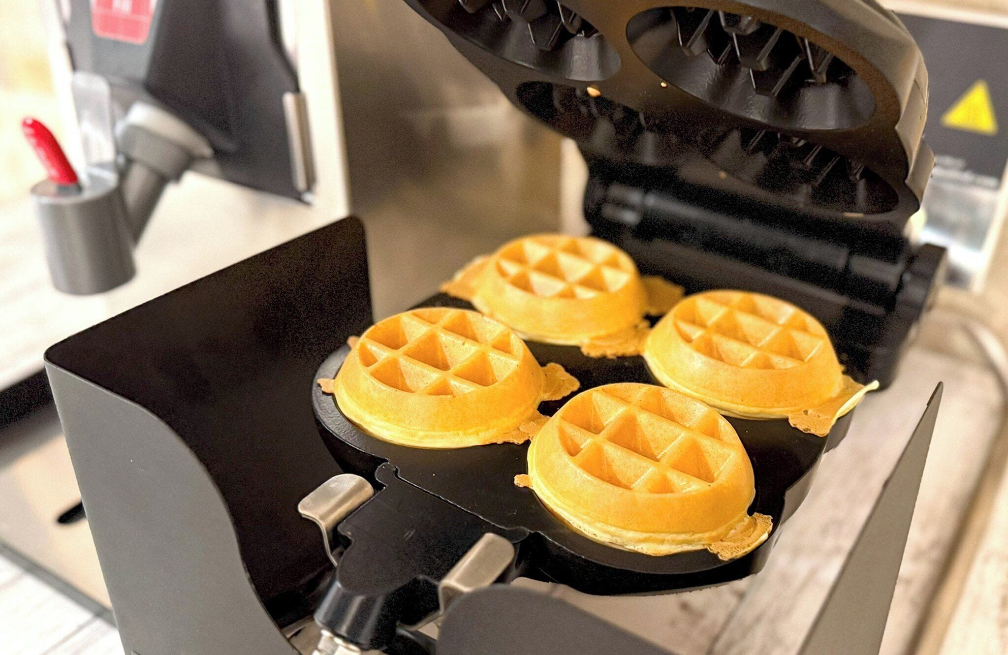 A waffle iron with four waffles inside.