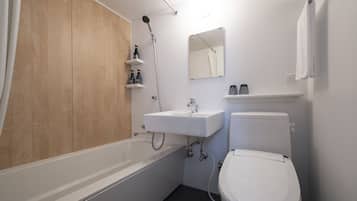 Une salle de bain moderne équipée d’une baignoire, d’un lavabo et de toilettes.