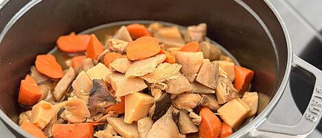 A pot containing a stew with chunks of meat and vegetables.