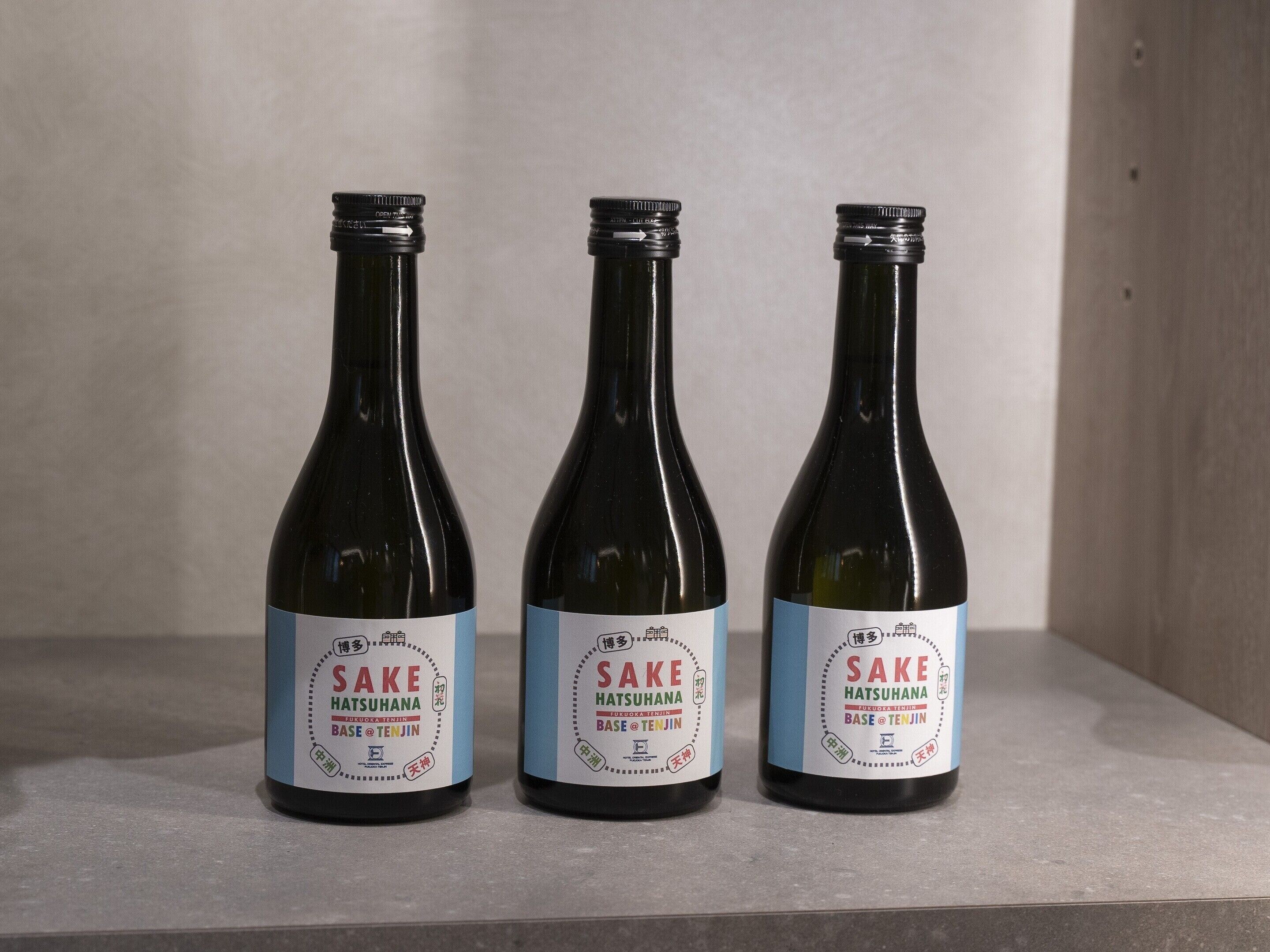 Three bottles of Sake Hatsuahana on a shelf.