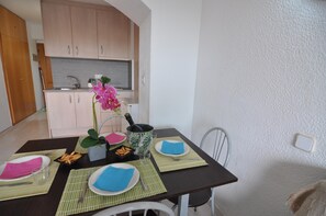 Ruokapöytä on katettu lautasilla, aterimilla ja samppanjapullolla.