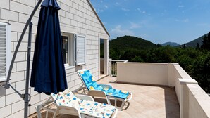 A balcony with two sun loungers and a blue umbrella. - Apartment Relax Ston (Ston)