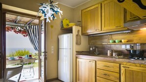 A kitchen with wooden cabinets, a refrigerator, and a view of the outdoors. - Villa Le Rondini - Two Bedroom Villa, Sleeps 4 (Ionian Islands)