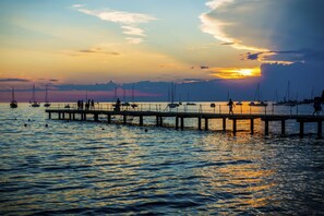 A pier extending into calm waters with boats anchored nearby.