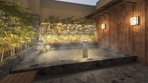 A hot spring area with stone steps leading into a heated pool, surrounded by bamboo plants and a wooden wall. - Dormy Inn Ikebukuro Hot Springs (Tokyo)