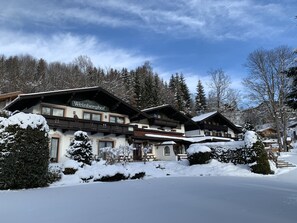 A traditional alpine-style hotel with multiple balconies and snow-covered surroundings. - Weinberghof I (Kirchberg in Tirol)
