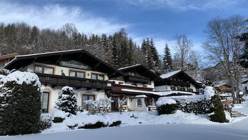 A traditional alpine-style hotel with multiple balconies and snow-covered surroundings.