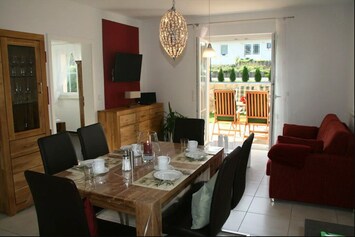 Wohnung 1: Blick in den Wohnbereich mit kleiner Terrasse