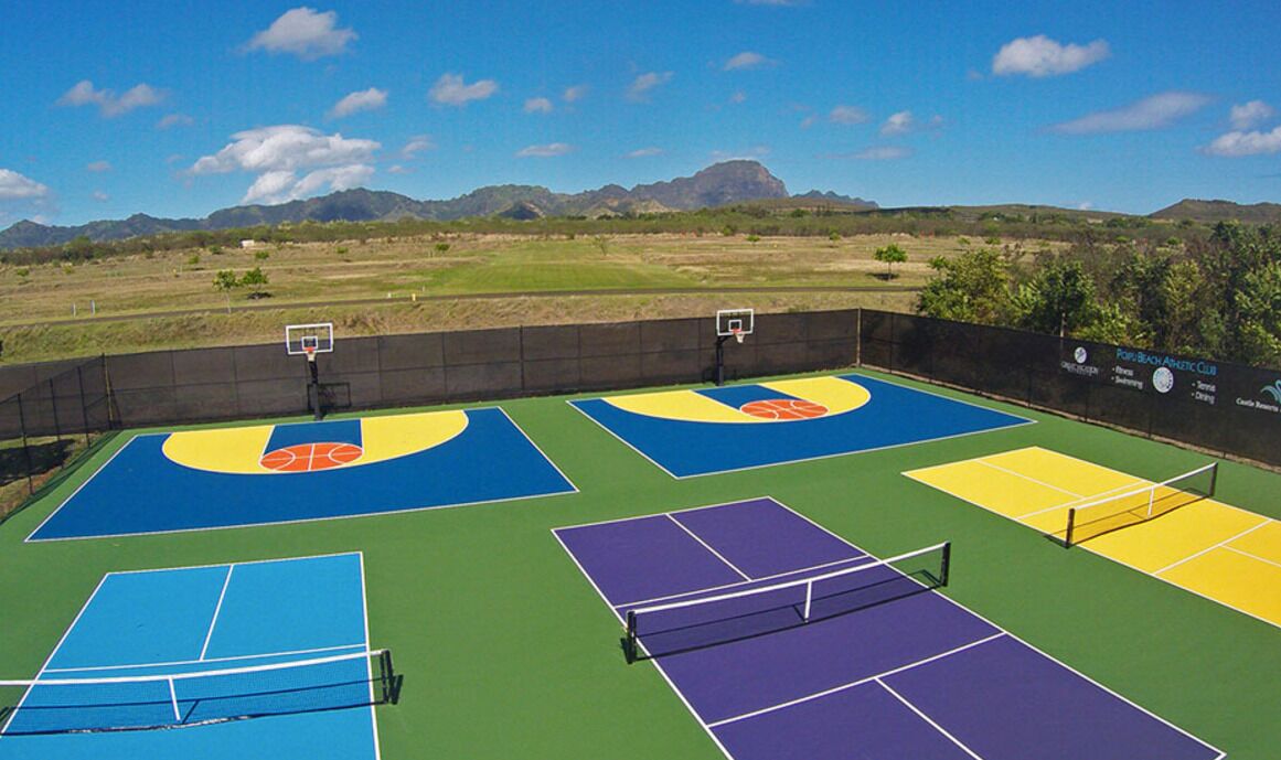 Una cancha de baloncesto al aire libre con varias canchas, una cancha de tenis y una red.