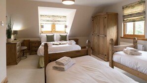 A bedroom with two beds, a desk, and a large window. - Rowan Cottage - Retreat Group (Aviemore)