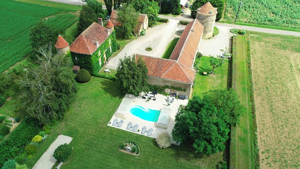 An aerial view of a property with a swimming pool, a tennis court, and a tower. - Les Granges du Château : Charming gîte with swimming pool in Burgundy (Chevannes)
