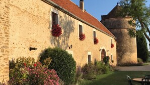 A building with a stone facade, multiple windows, and a turret. - Les Granges du Château : Charming gîte with swimming pool in Burgundy (Chevannes)