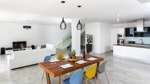 Ein stilvoller Wohnraum mit Essbereich, Küche und einer Treppe zu einer oberen Ebene.