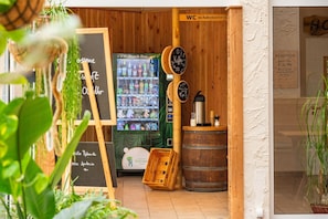 Un café chaleureux avec un décor intérieur en bois, un comptoir où l’on peut prendre une collation et une machine à café.