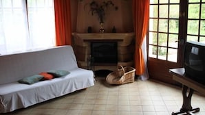 Een gezellige woonkamer met een bank, een open haard en een televisie.