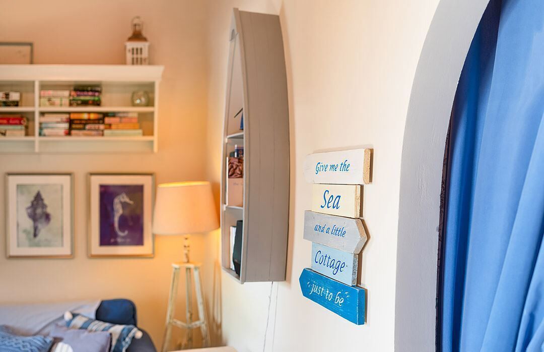 Een kamer met een bed, een boekenkast en een bord aan de muur met tekst.