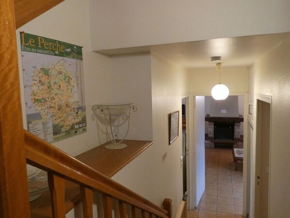 Una escalera conduce a un comedor con un mapa y una mesa.