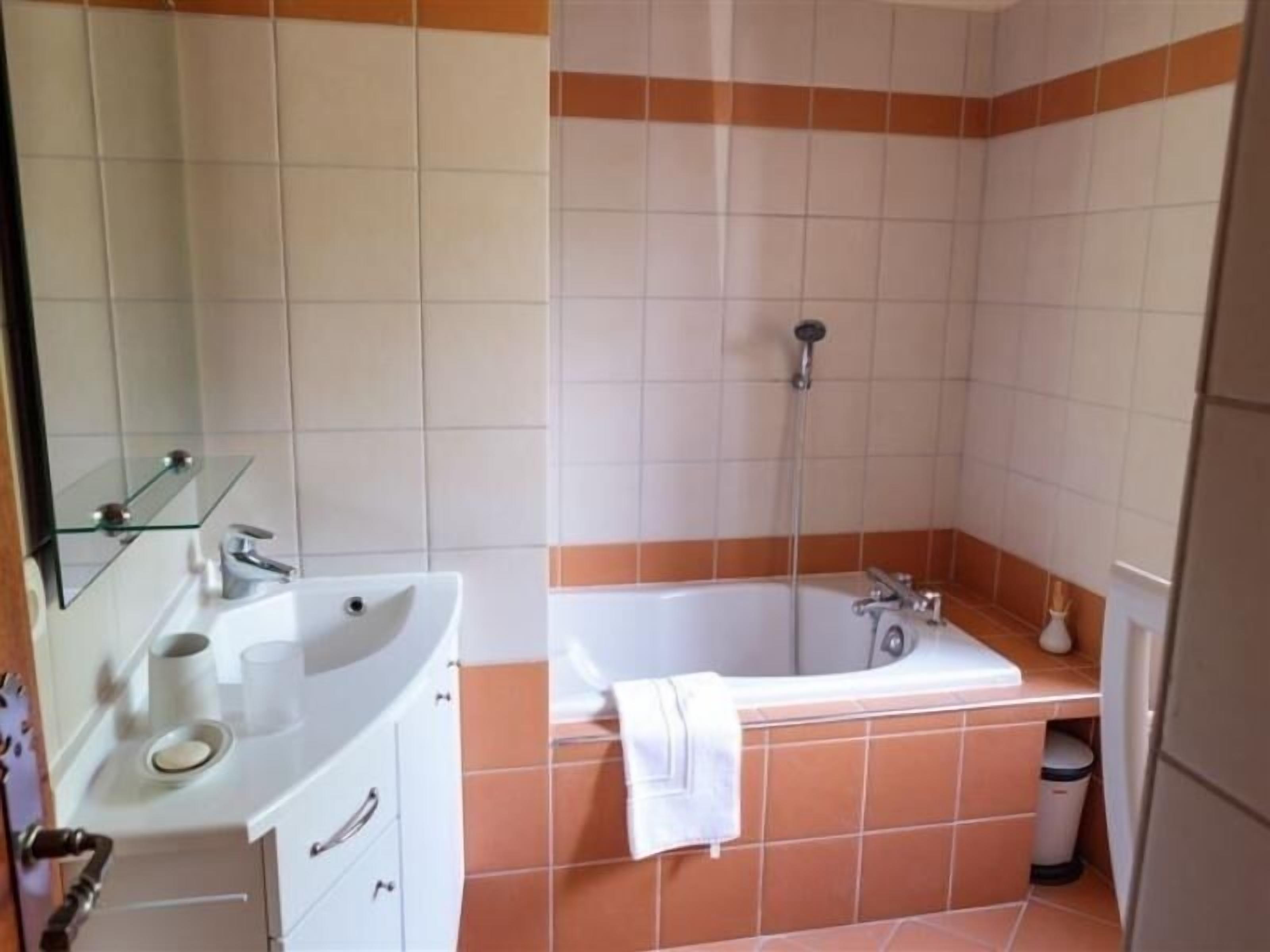 Un bagno con lavandino, specchio e vasca da bagno.