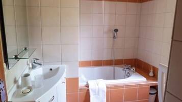 Un bagno con lavandino, specchio e vasca da bagno.