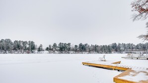 Ein verschneiter Außenbereich mit Holzbanken und einem Picknicktisch.