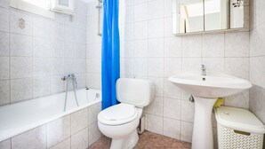 A bathroom with a bathtub, toilet, and sink.