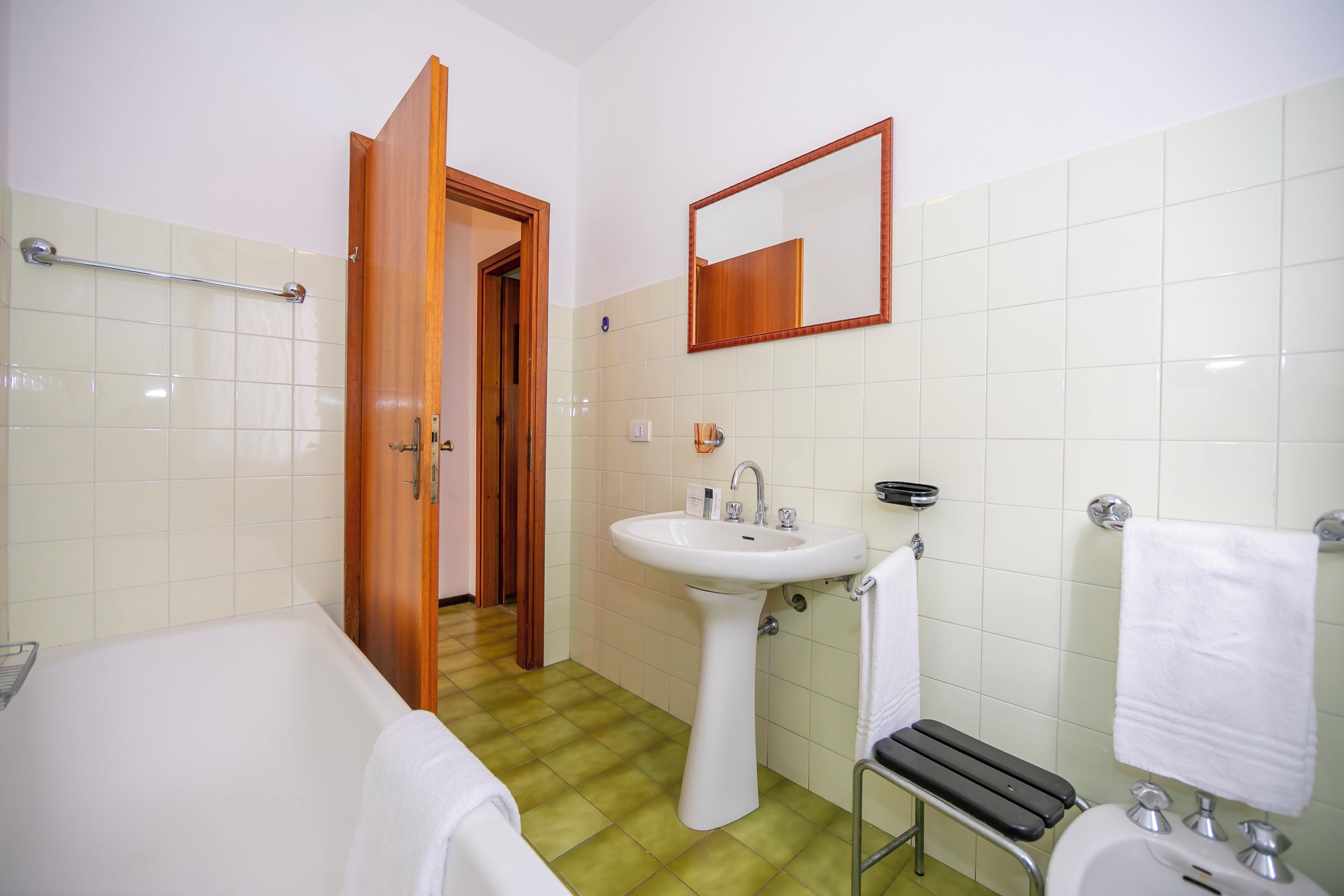 Un baño con bañera, lavamanos y espejo.